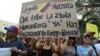 Venezuelans in Colombia protest the government of Venezuela and its blocking of humanitarian aid in Cucuta, Colombia, Feb. 12, 2019. The sign reads, "Urgent. The entry of humanitarian help is needed now. There are Venezuelans at risk of dying."