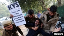 A demonstrator is detained by police outside the Assam bhawan (building) during a protest against a new citizenship law, in New Delhi, Dec. 23, 2019. 