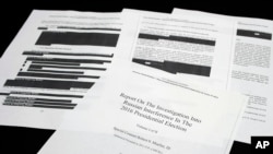FILE - Four pages of the Mueller Report are seen on a witness table in the House Intelligence Committee hearing room on Capitol Hill, in Washington, April 18, 2019.