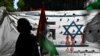 Seorang pengunjuk rasa memegang bendera Palestina saat unjuk rasa mendukung rakyat Palestina di depan kedutaan Israel di Buenos Aires, pada 9 Oktober 2023, setelah Israel memberlakukan pengepungan total di Jalur Gaza dan memutus pasokan air. (Foto: AFP)