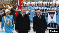 Russia's President Vladimir Putin, right, and Turkey's President Recep Tayyip Erdogan review an honor guard during a welcoming ceremony at the Presidential Palace in Ankara, Dec. 1, 2014. 