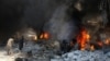 Men try to put out a fire at a market hit by air strikes in Idlib city, Syria June 12, 2016. 