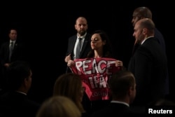 Demonstrantkinju koja drži transparent "Mir sa Iranom" izvode van sobe tokom obraćanja državnog sekretara SAD Majka Pompea grupi Ujedinjeni protiv nuklearnog Irana, na marginama zasedanja Generalne skupštine UN, u sjedištu Ujedinjenih nacija, u Njujorku, 25. septembra 2018.