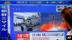 Žena prolazi pored TV ekrana preko koga se emituje vest o severnokorejskoj raketnoj probi, u Tokoju, Japan.
