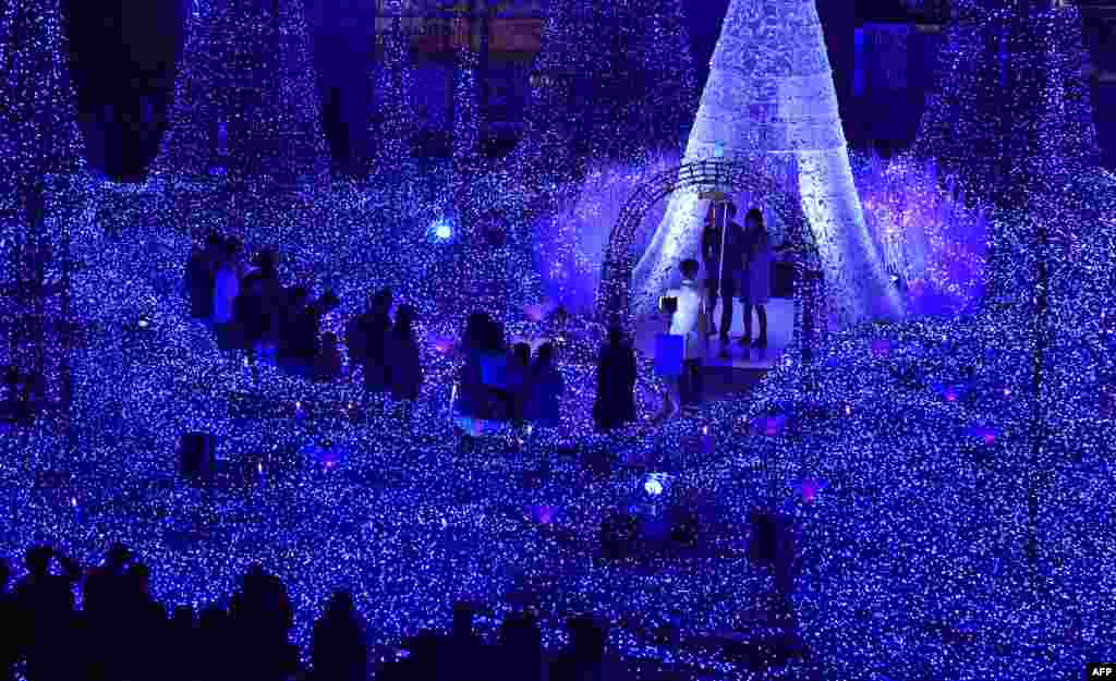 People admire illuminations featuring the theme of "Canyon d'Azur" (Blue Canyon) at Caretta Illumination in Tokyo, Japan.
