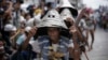 FILE - Wearing their traditional warrior helmets and jewelry, Tao aboriginal elders arrive at a traditional fishing boat launching ceremony in a village on Orchid Island, Taiwan.