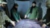 FILE - This undated photo released in 2016 shows Abu Mohammed al-Golani, second right, discussing battlefield details with field commanders over a map in Aleppo, Syria. HTS leader al-Golani has pledged to respect the rights of ethnic and religious minorities.