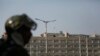 An Indian paramilitary soldier stands guard as the Indian national flag flies atop the government secretariat in Srinagar, Indian controlled Kashmir, Oct. 31, 2019. 