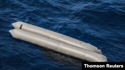 A rubber boat is seen after having capsized with more than 100 migrants on board, during a search and rescue operation in the Mediterranean Sea, off the Libyan Coast, April 22, 2021.
