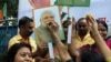 A supporter of India's ruling Bhartiya Janata Party (BJP) feeds sweets to a portrait of Prime Minister Narendra Modi as she celebrates with others the revocation of Kashmir's special constitutional status, in Mumbai, Aug. 6, 2019. 