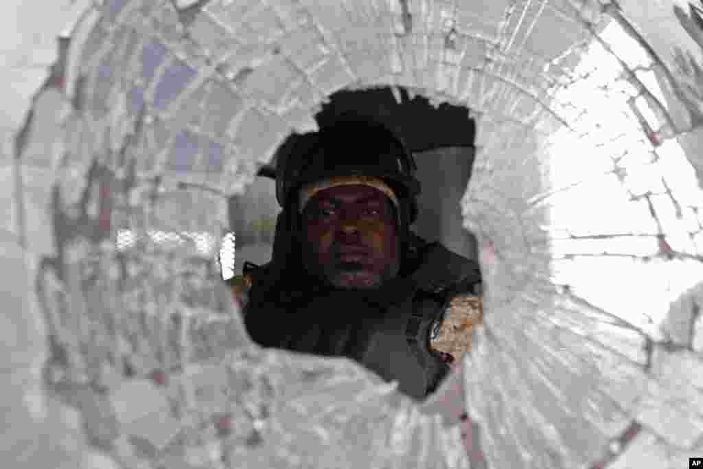 A police officer drives a police truck with its windshield smashed during a protest by supporters of presidential candidate Maryse Narcisse in Port-au-Prince, Haiti, Nov. 21, 2016.