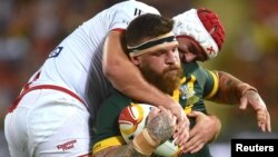 FILE - England's Chris Hill tackles Australia's Josh Mcguire during а match of the Rugby League World Cup, in Land Park, Brisbane, Australia, Dec. 2, 2017.