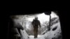 A Ukrainian Military Forces serviceman walks along a snow covered trench on the front line with the Russia-backed separatists near Zolote village, in the eastern Lugansk region, on Jan. 21, 2022.