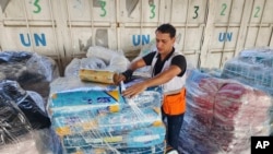 Seorang pekerja PBB menyiapkan bantuan untuk didistribusikan kepada warga Palestina di gudang UNRWA di Deir Al-Balah, Jalur Gaza, 23 Oktober 2023. (Foto: AP)