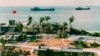 FILE - This photo released by the Military Information Agency in Taiwan shows two Taiwanese warships docking near the shore of Taiping Island, the largest of the disputed Spratly Island chain, with the Taiping military base in the foreground. 