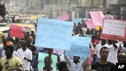 Protesters hold placards and shout slogans on Ikorodu road in Nigeria's commercial capital Lagos January 3, 2012. Hundreds of demonstrators in Nigeria's commercial capital Lagos shut petrol stations, formed human barriers along motorways and hijacked buse
