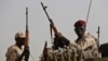 FILE - Sudanese soldiers from the Rapid Support Forces unit, led by Gen. Mohammed Hamdan Dagalo, the deputy head of the military council, secure the area where Dagalo attends a military-backed tribe's rally, in the East Nile province, Sudan, June 22, 2019. 