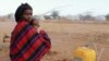 FILE - A refugee woman and her child from Somalia sit in the open as they camp with their belongings outside Ifo refugee camp in Dadaab, near the Kenya-Somalia border, July 30, 2011.