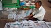 A vendor arranges newspapers with headlines about Supreme Court's verdict on a disputed religious site claimed by both majority Hindus and Muslim in Ayodhya, in Ahmedabad, India, Nov. 9, 2019. 