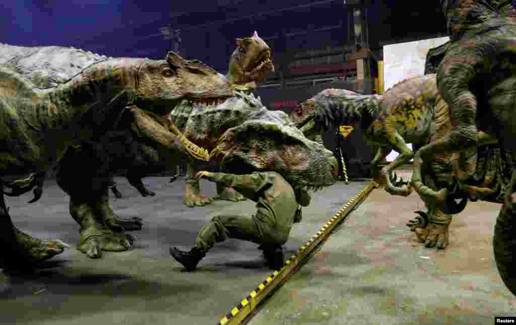 Japan's ON-ART Corp's eight-meter tall man-operated walking dinosaur robot 'TRX03' (C) performs with other robots at the company's studio in Tokorozawa.
