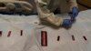 Registered nurse Bryan Hofilena attaches "COVID Patient" stickers on a body bag of a patient who died of coronavirus at Providence Holy Cross Medical Center in Los Angeles, Dec. 14, 2021.