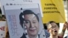 An activist holding a placard showing the merged faces of Taiwan's President Ma Ying-jeou and China's President Xi Jinping, protests against the upcoming Singapore meeting between Ma and Xi, in front of the Presidential Office in Taipei, Taiwan, November