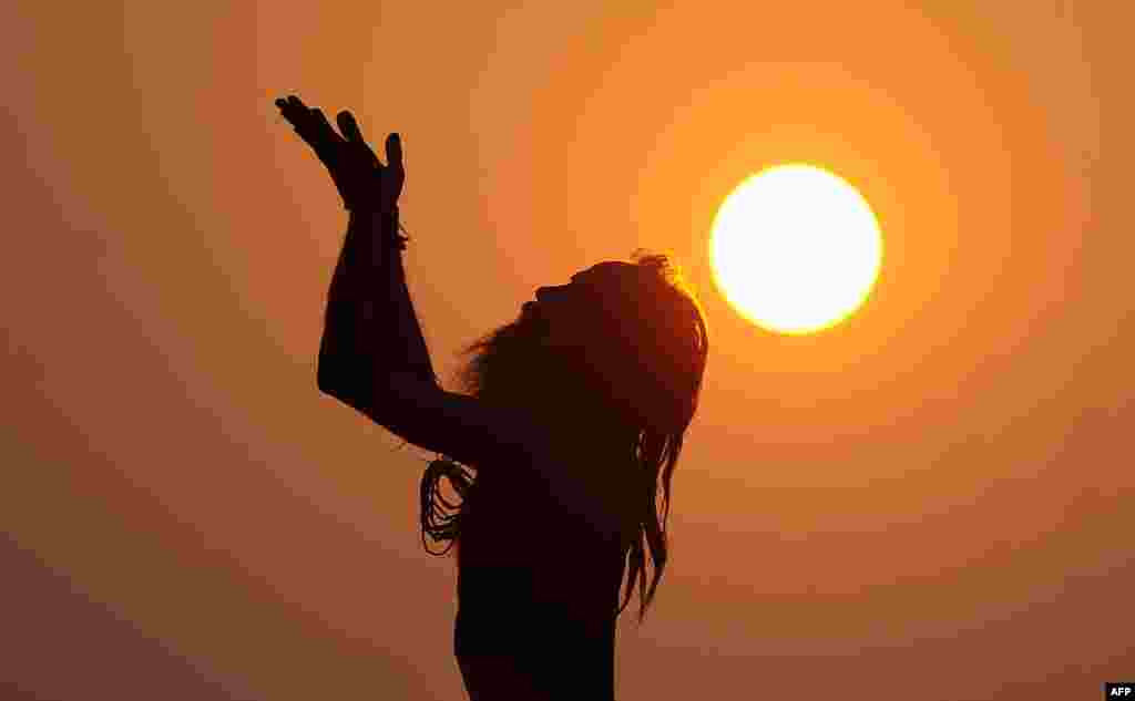 An Indian sadhu - holy man - performs yoga at sunrise at the Dashashwamedh Ghat in Varanasi.
