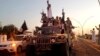 FILE - Fighters from the Islamic State group parade in a commandeered Iraqi security forces armored vehicle down a main road at the northern city of Mosul, Iraq, June 23, 2014.