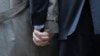 Mark Phariss (L) clutches the hand of partner Victor Holmes as they talk to the media outside the U.S. Federal Courthouse in San Antonio, Texas, Feb. 12, 2014.
