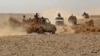 FILE - Fighters ride in pickup trucks as forces loyal to Yemen's Saudi-backed government clash with Houthi rebels in al-Jadaan, in Yemen's Marib governorate, Nov. 22, 2020.
