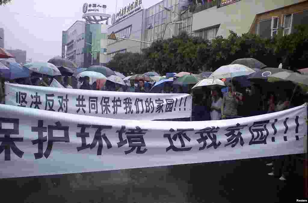 Local residents parade with banners during a protest along a street in Shifang county, Sichuan province, China, in this handout picture taken on July 2, 2012.
