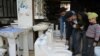 FILE - A store employee shows toilets to customers in a hardware showroom in Amritsar, India, Nov. 18, 2017.
