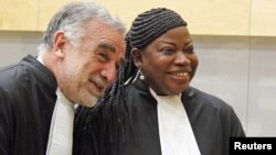 ICC prosecutor Fatou Bensouda shares a laugh with her predecessor Luis Moreno-Ocampo (L) at the ICC, The Hague, Netherlands, June 15, 2012. 