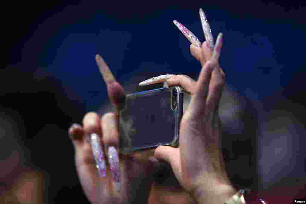 A spectator takes a picture at the Barclays ATP World Tour Finals tennis tournament in London.