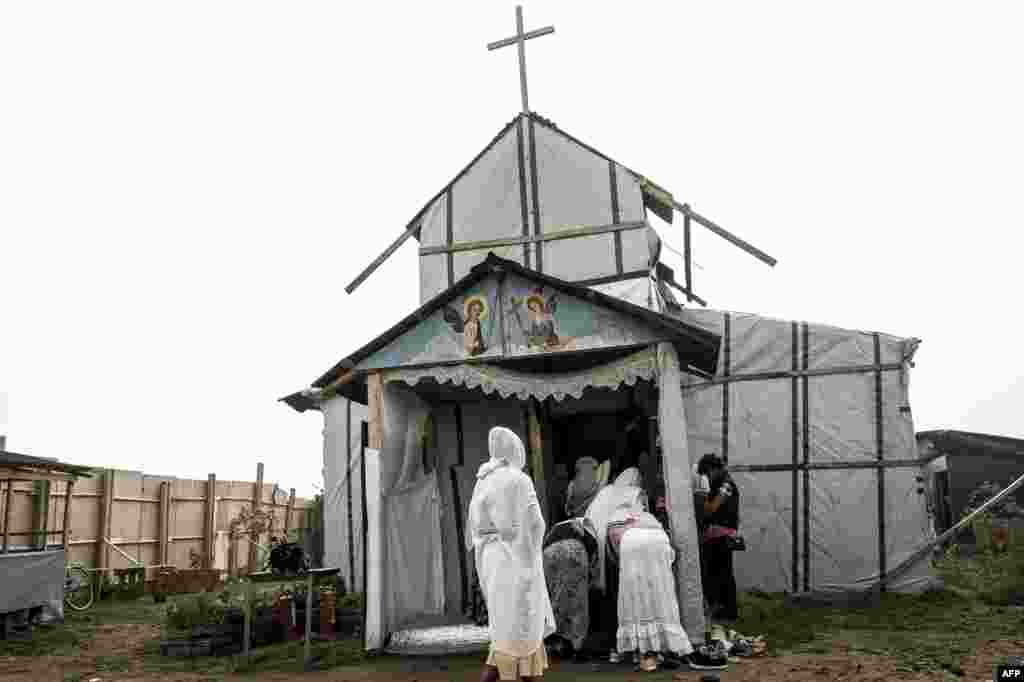 Ethiopian Coptic migrants arrive for a Mass at the makeshift Orthodox church in "the Jungle" migrant camp in Calais, northern France.