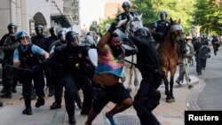 Specijalne policijske snage pokušavaju da potisnu demonstrante iz parka Lafajet blizu Bele kuće da bi predsednik Donald Tramp mogao da prođe do obližnje crkve Svetog Jovana, 1. jun 2020. godine