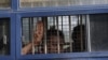 A man flashes the three-finger salute after being arrested during a protest against the military coup in Mawlamyine, Myanmar, Feb. 12, 2021. 
