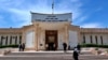 FILE - People walk outside Iraqi Criminal Court in Baghdad's Karkh district, Iraq, May 5, 2019. On Wednesday, a wife of deceased Islamic State leader Abu Bakr al-Baghdadi was sentenced to death for allegedly helping detain Yazidi women.  