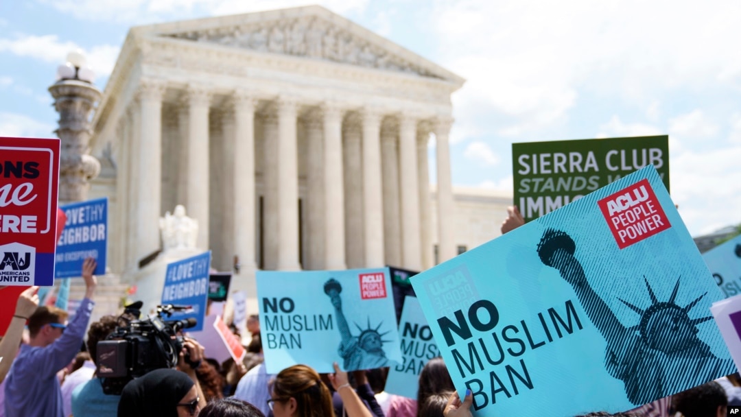 Protesters hold up signs and call out against the Supreme Court ruling upholding President Donald Trump's travel ban outside the the Supreme Court in Washington, June 26, 2018.