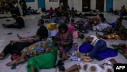 TOPSHOT - Voters gather and rest on the floor at the end of the voting day in a polling station at the Reverend Kim School in Kinshasa on December 20, 2023.