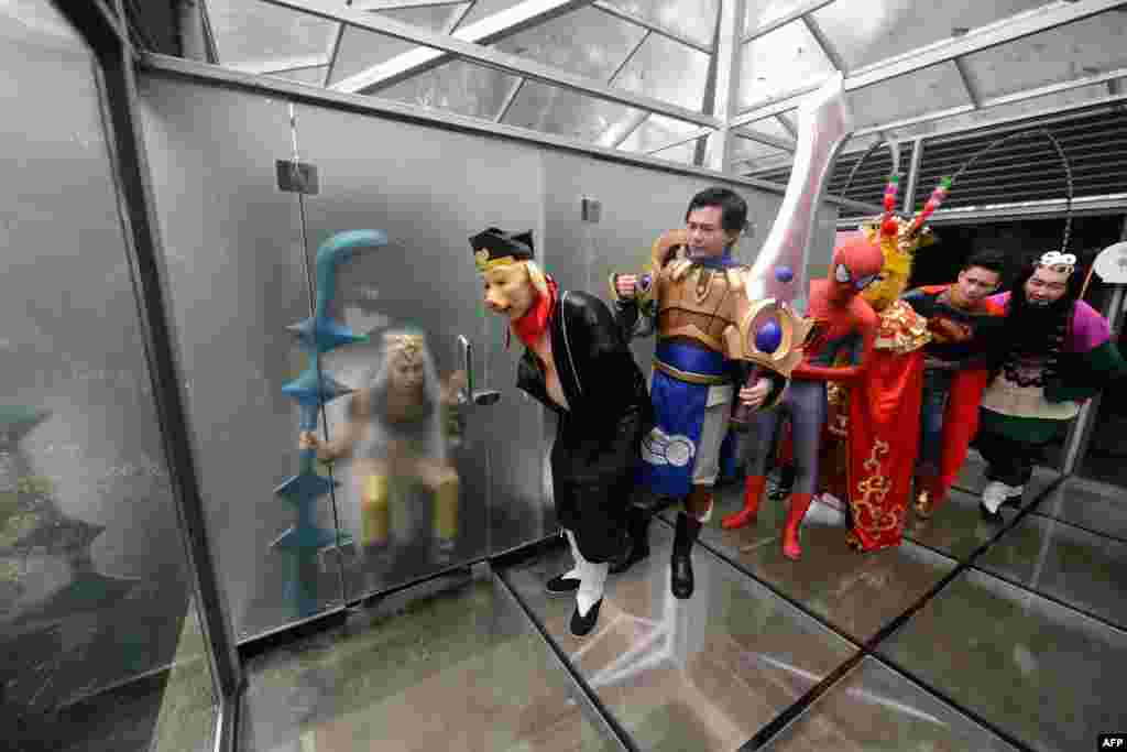 Cosplay actors pose for photos in a glass public toilet to mark World Toilet Day in Changsha in China's central Hunan province, Nov. 19, 2016.