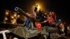 People stand on a Turkish army tank in Ankara, Turkey, July 16, 2016. 