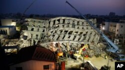In the early morning, emergency rescuers continue to search for the missing in a collapsed building from an earthquake in Tainan, Taiwan, Feb. 7, 2016. 