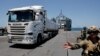Trucks carry humanitarian aid across Trident Pier
