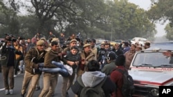 A protesting student is detained by a policemen outside Uttar Pradesh Bhawan during a protest against a new citizenship law and violence by police in the state, in New Delhi, India, Dec. 27, 2019. 