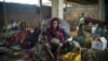 FILE - A 19-year-old woman and her children wait for their first hot meal in over two months at the Dosseye refugee camp in Chad. They arrived after fleeing violence in C.A.R.